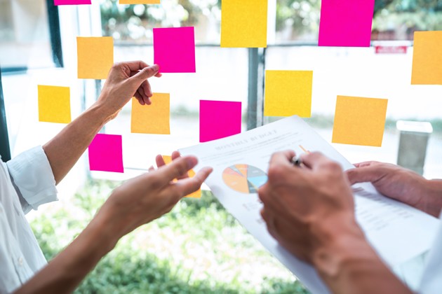 Business Team Using Post It Notes On Glass Wall